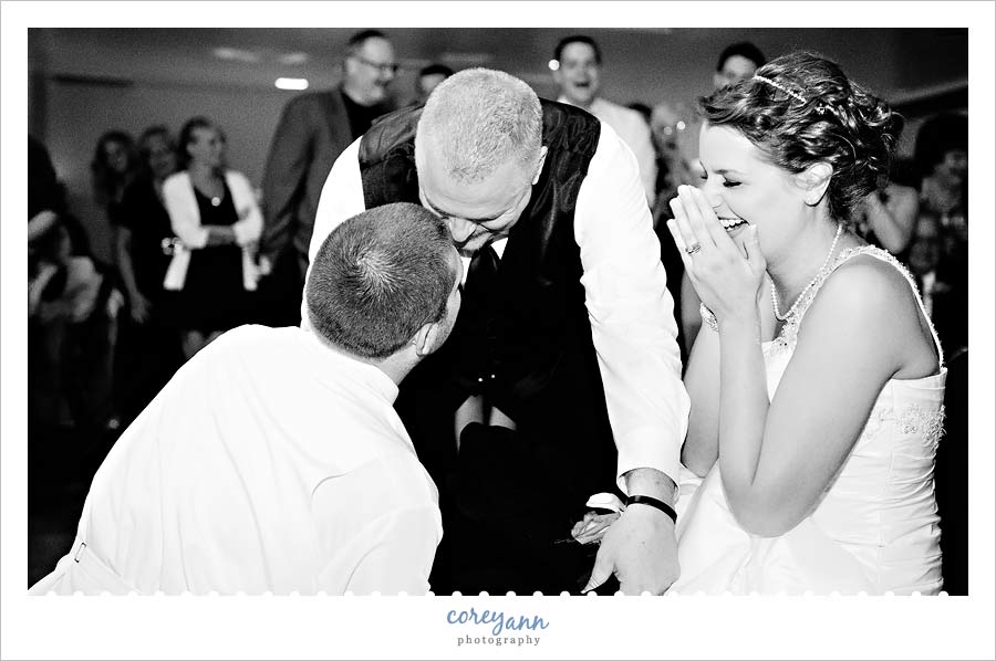 bride's dad blocking groom from removing garter with his jacket