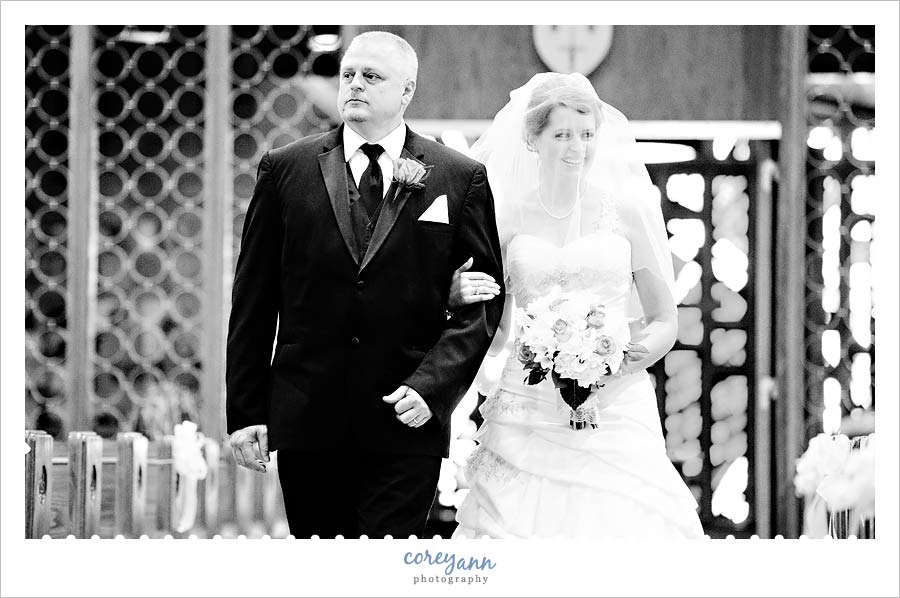 bride and her father walking down aisle before wedding at st joan of arc