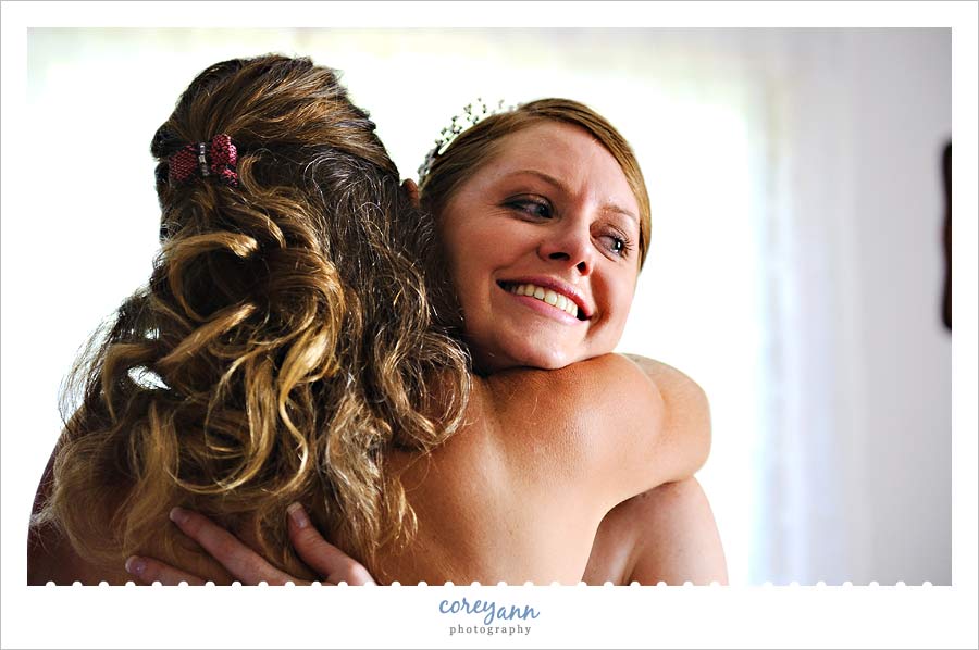 bride hugging mom while getting ready with a tear in her eye