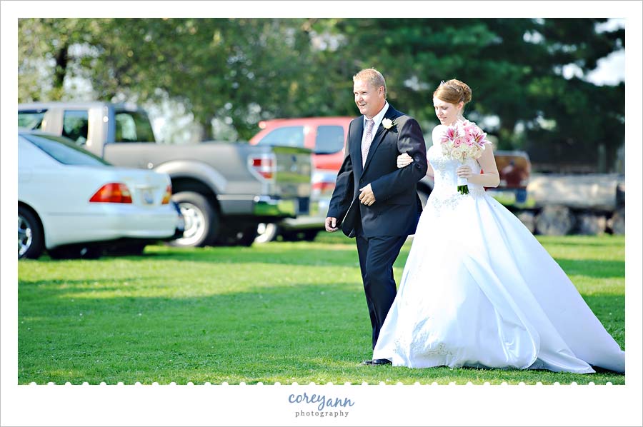 bride and father getting ready to walk down aisle in parents backyard