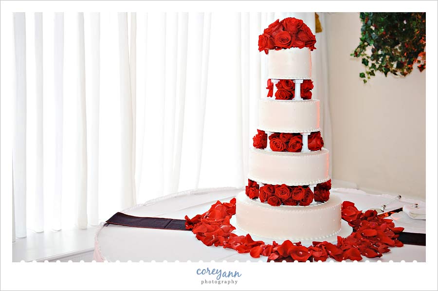 Maureen & Jeremy's Wedding at Pine Ridge Golf Course white cake with red roses and rose petals in wickliffe ohio