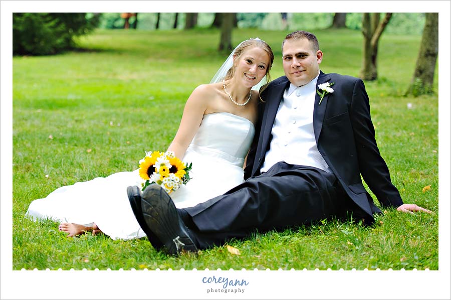 Chrissanna and Robert's Wedding in Akron bride and groom sitting in grass in akron ohio