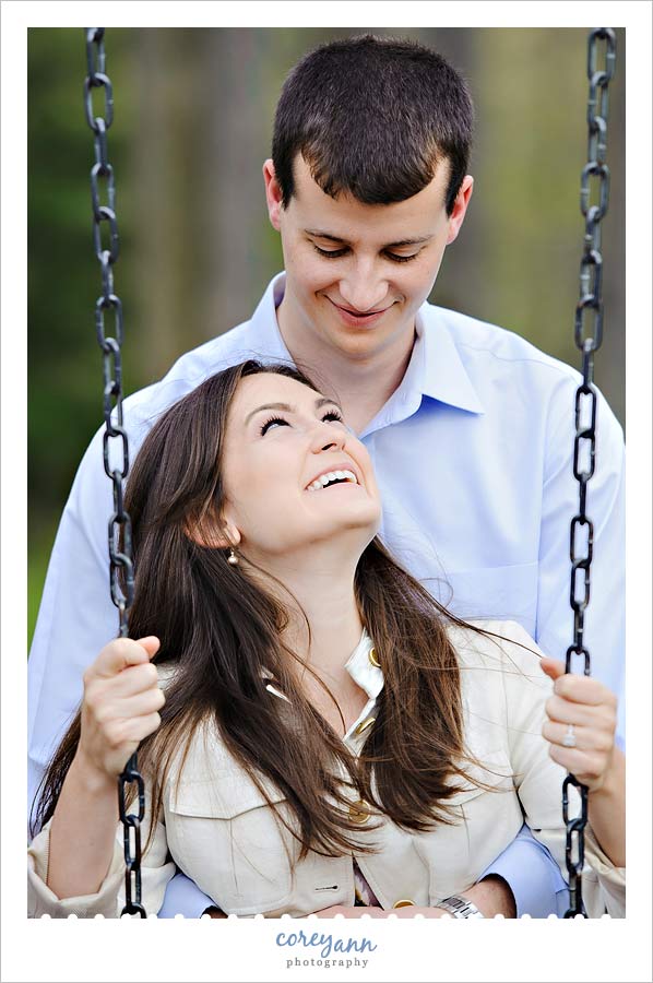 engaged couple on swingset in brecksville metro park