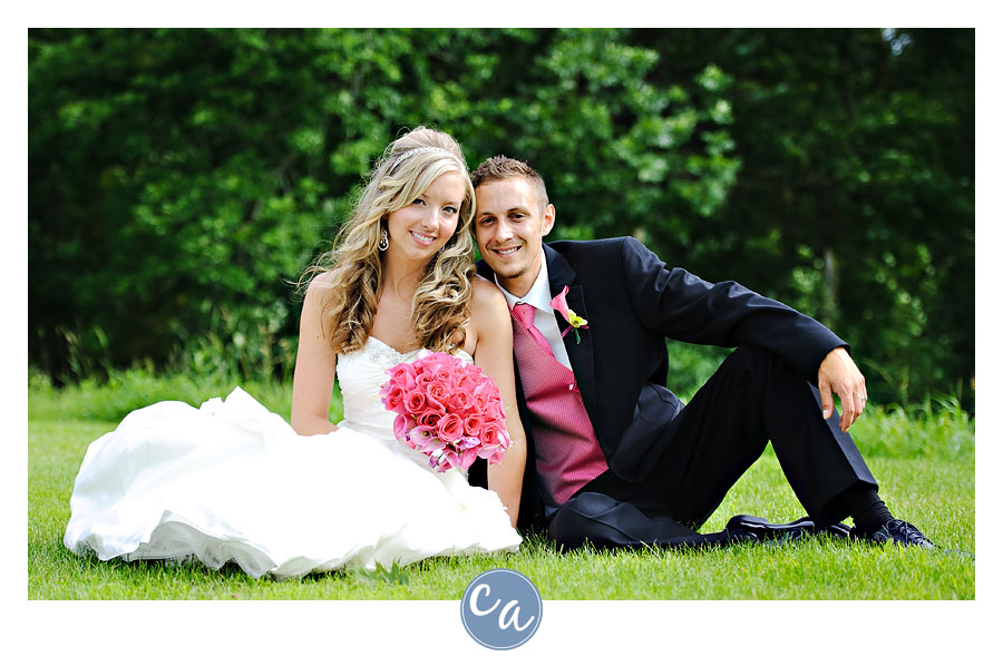 bride and groom sitting in a field in sugarcreek ohio