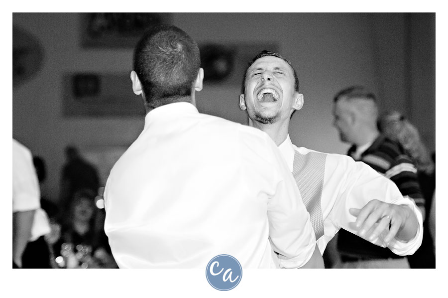 groom and groomsman dancing together during money dance