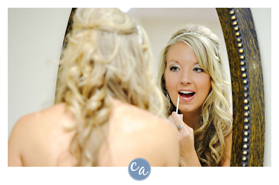 bride putting makeup on in mirror