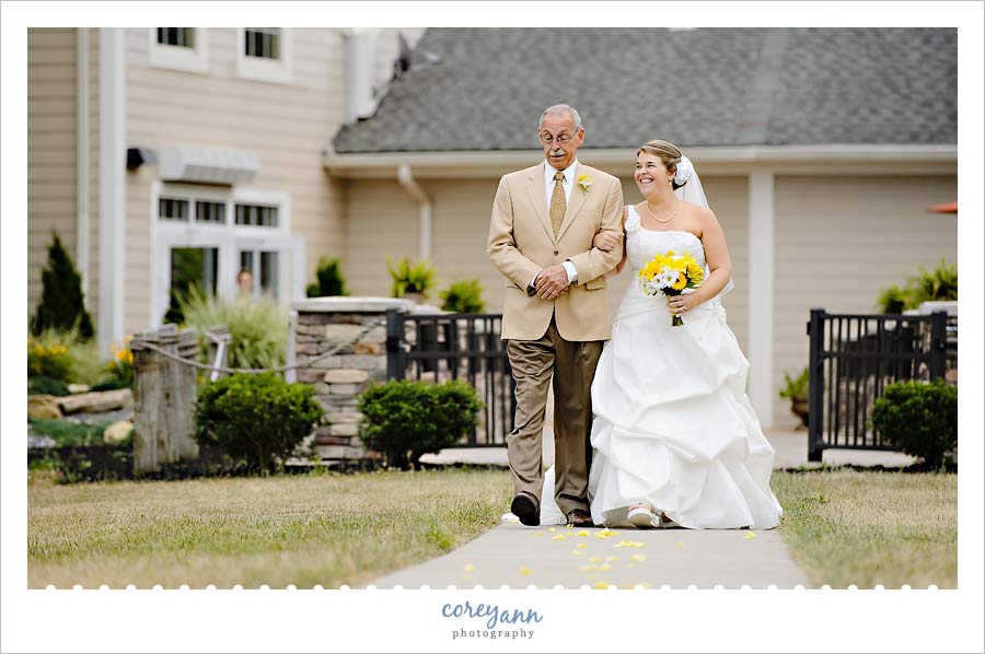 bride and father walking down aisle at wedding ceremony