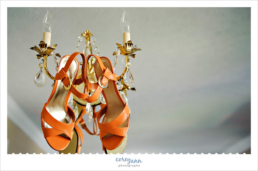 bridal shoes hanging on chandelier