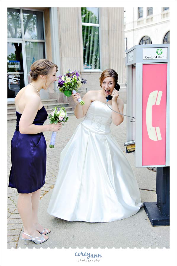 bride talking on payphone after wedding