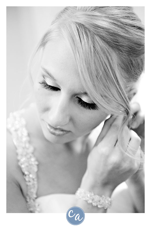 bride putting in earrings while getting ready