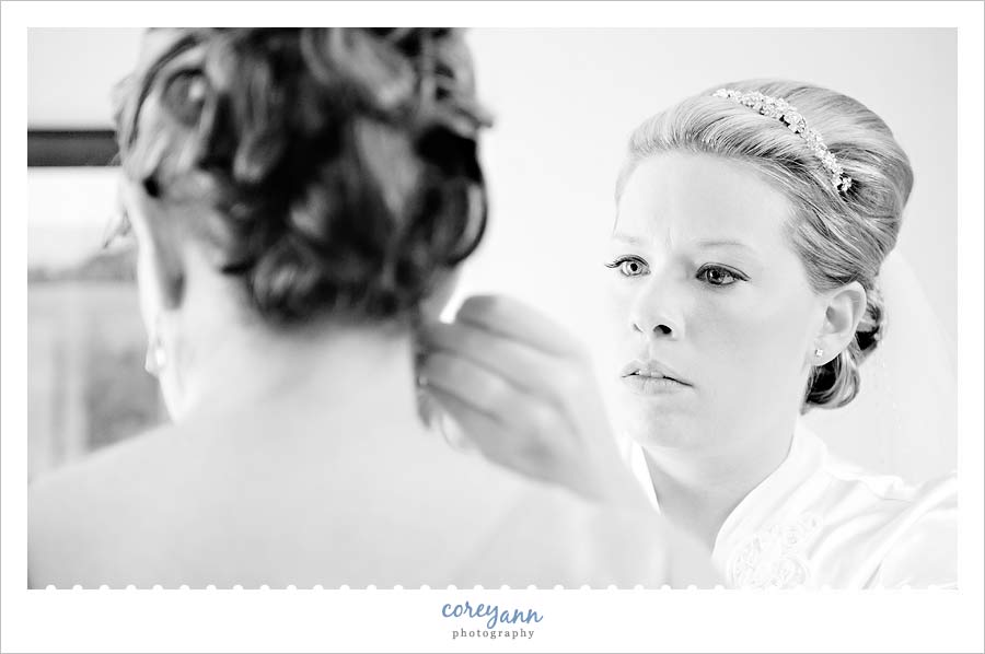 bride helping mother put on earrings at the shearaton suites in cuyahoga falls