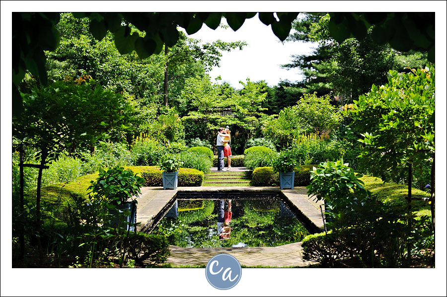 couple posing in english garden near reflection pool at stan hywet