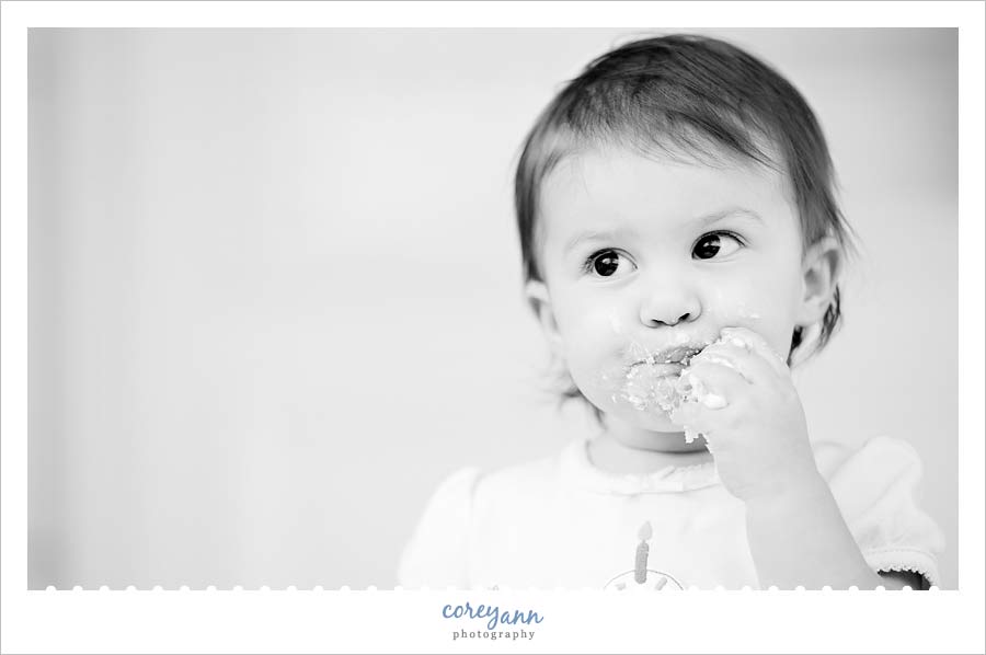 Miss Margaux | 1 Year black and white of 1 year old eating cake