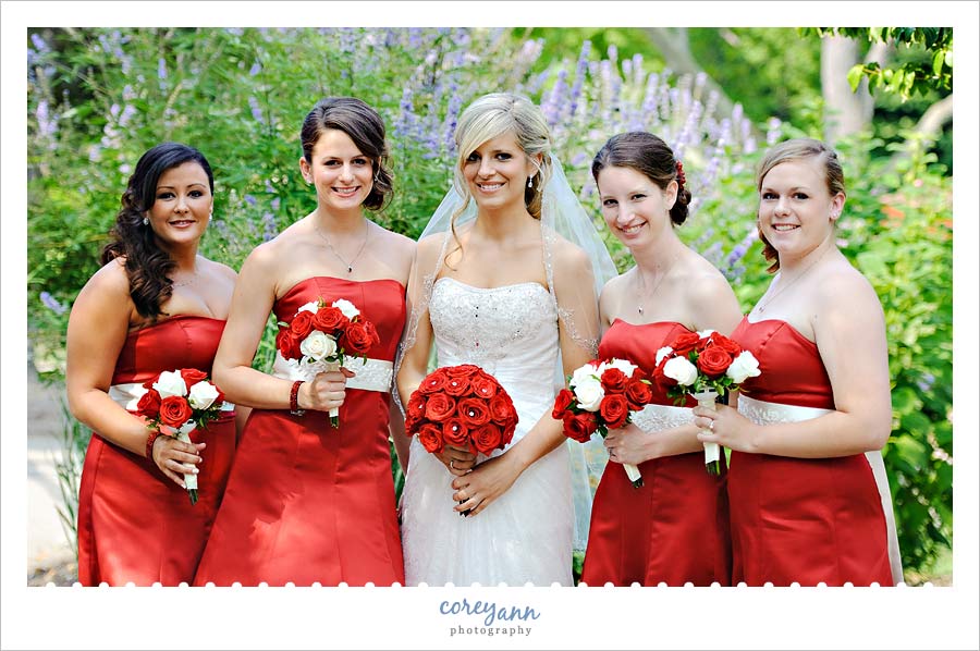 bride and bridesmaids in red dresses in garden in wickliffe ohio