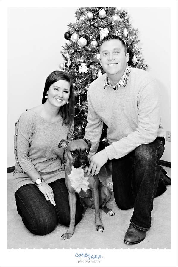 family portrait with dog in front of christmas tree