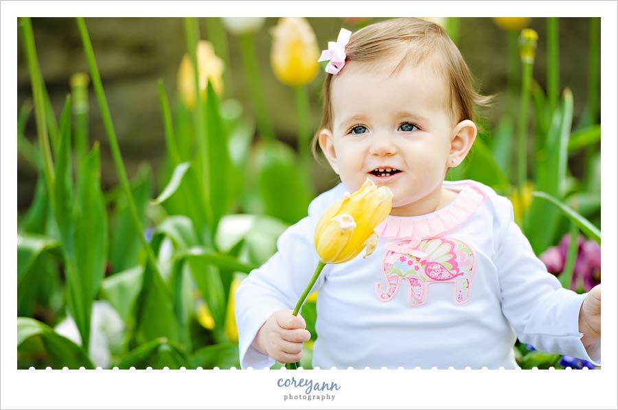 Family Portrait Session at Fellows Riverside Gardens one year old child sitting in tulips at fellows riverside gardens