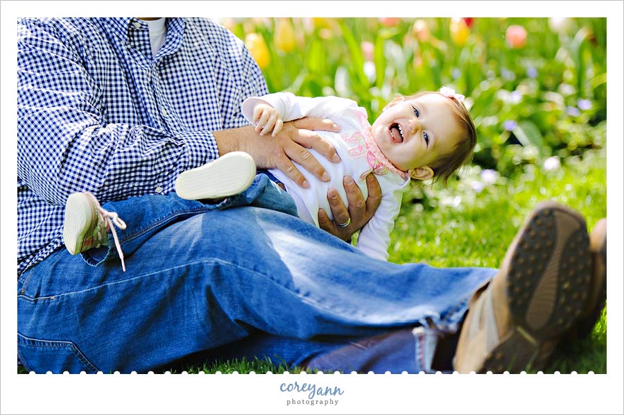 Family Portrait Session at Fellows Riverside Gardens one year old girl giggling while playing with her dad