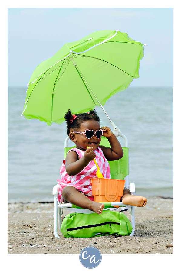 one year old wearing sunglasses on the beach
