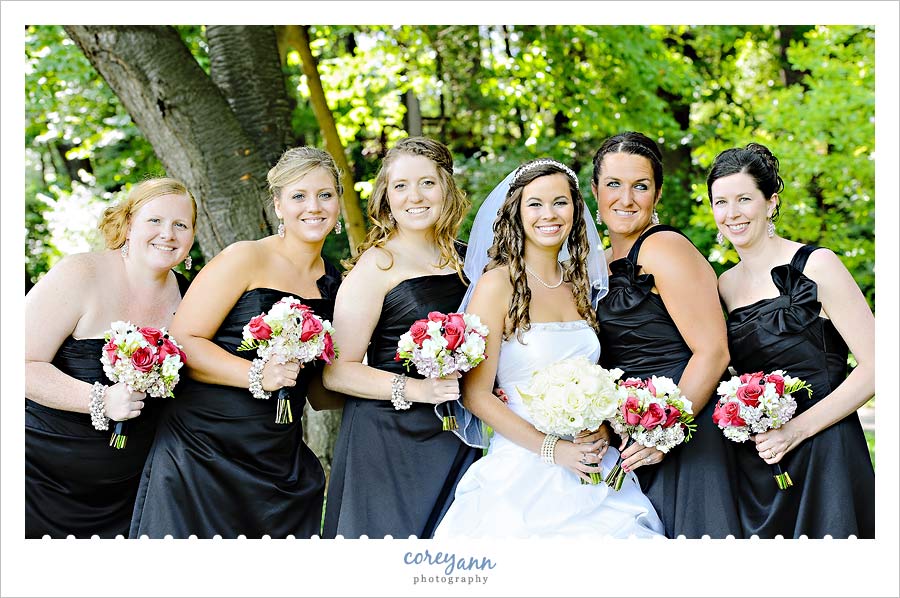 bridesmaids in black dresses with hot pink and white bouquets