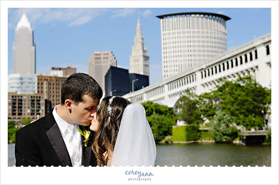 bride and groom with cleveland skyline behind them
