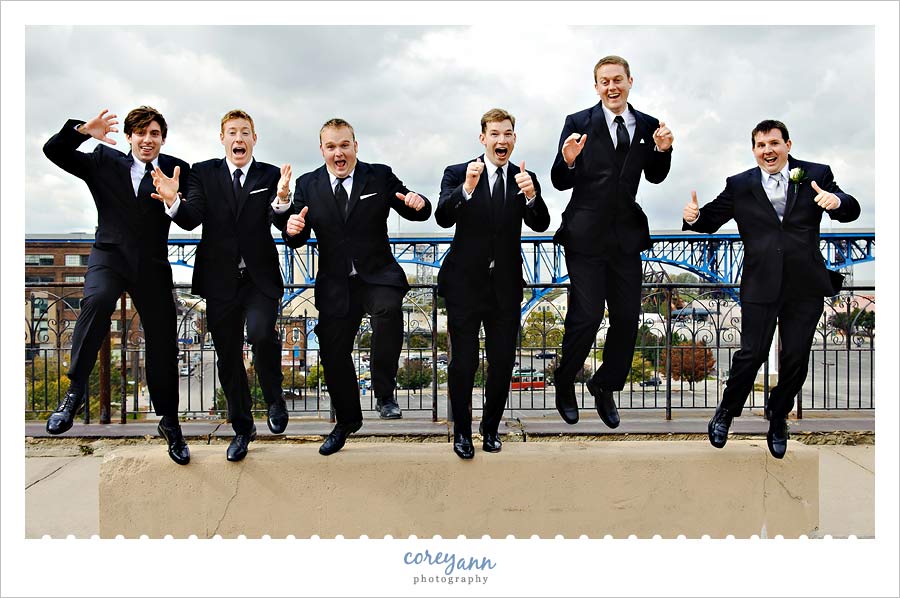 groom and groomsman jumping in downtown cleveland ohio