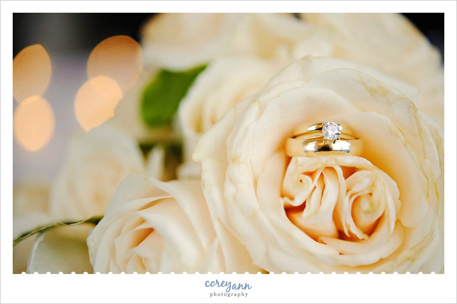 wedding rings on cream rose bouquet