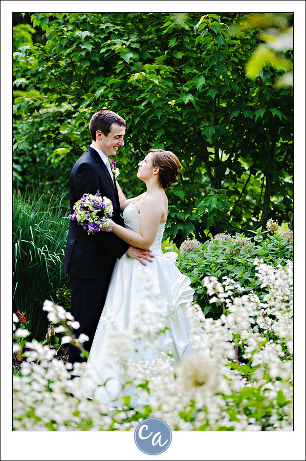 bride and groom embrace near flowers