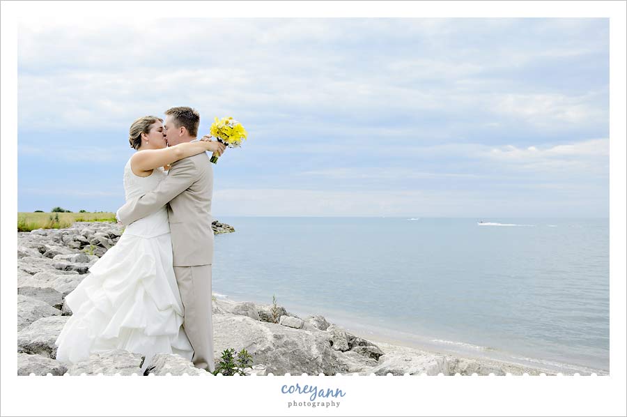 bride and groom kissing on the shores of lake erie