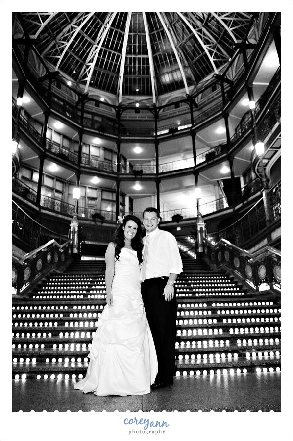 bride and groom pose on stairs at the arcade