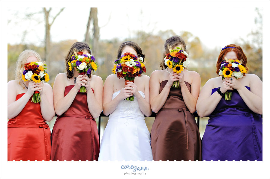 bride and bridesmaids in multi colored dresses with matching bouquets