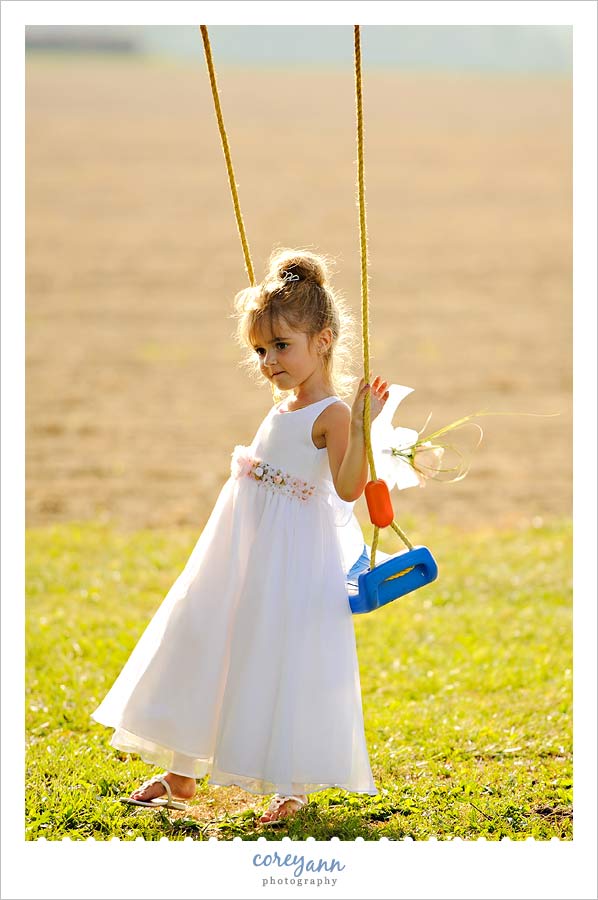 flower girl on swing at backyard wedding in Ohio