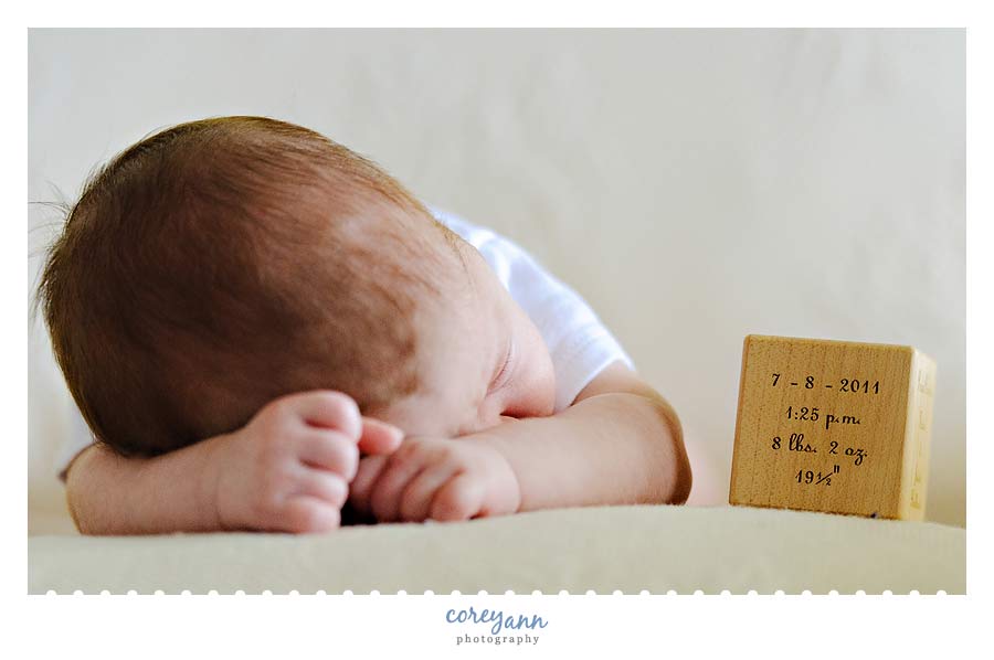 baby boy with wooden block at 6 weeks old