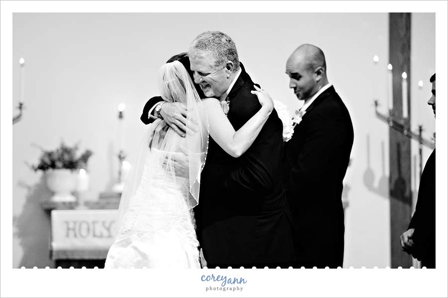 father of bride hugging daughter