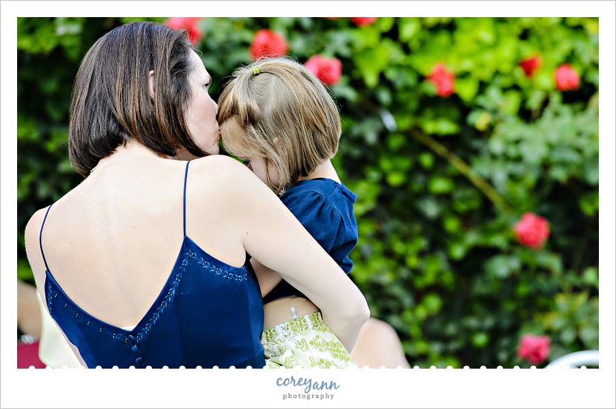 mom kissing flower girl at wedding
