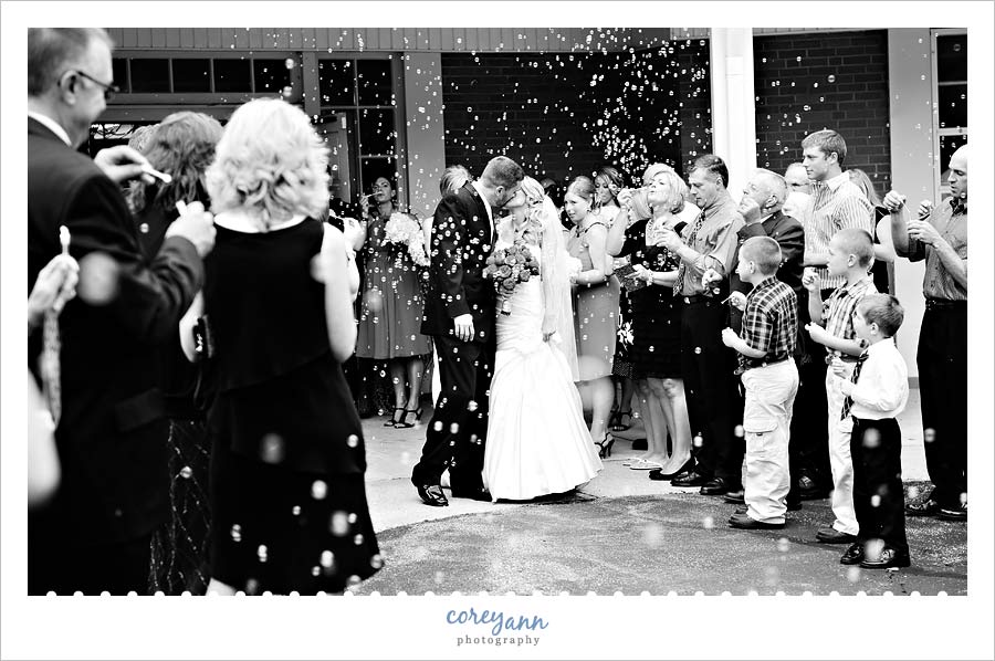 bride and groom kiss during bubble exit from ceremony