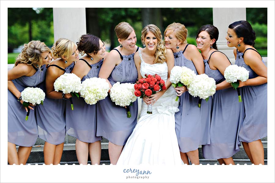 bridesmaids in grey dresses with red bouquets