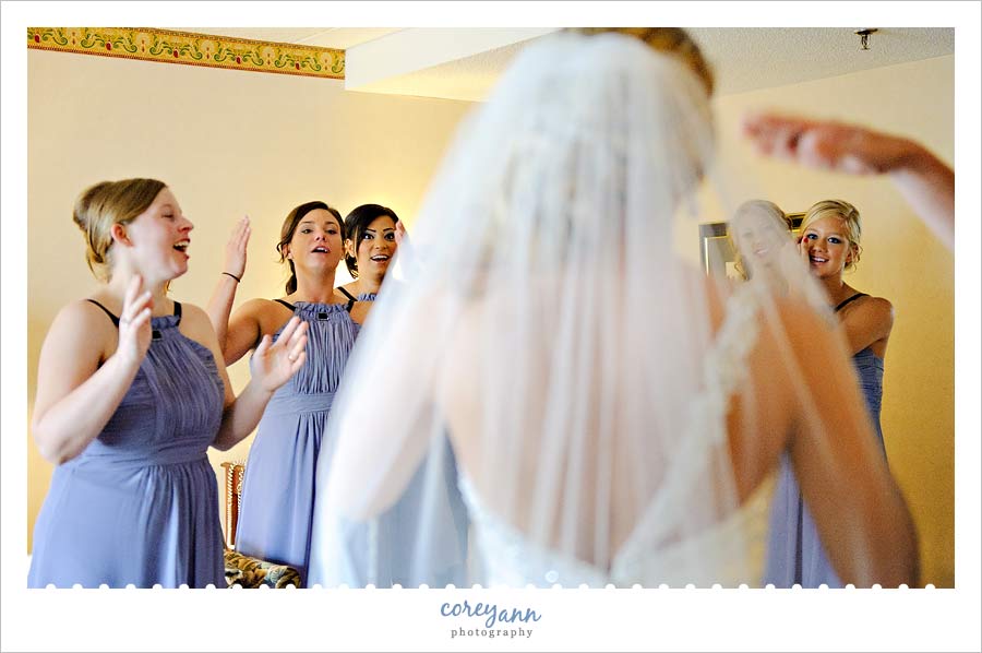 bride revealing the final look to her bridesmaids