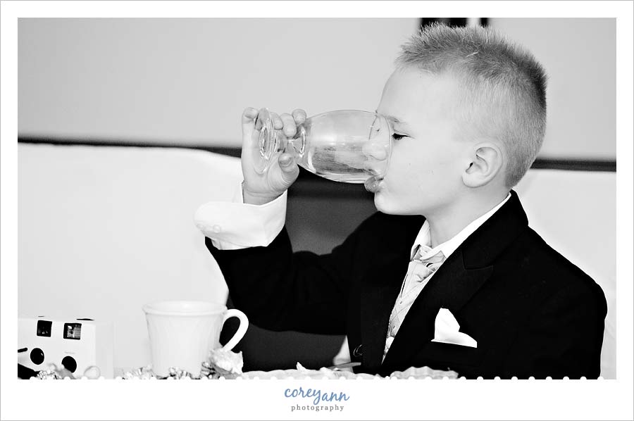 ring bearer drinking out of a glass