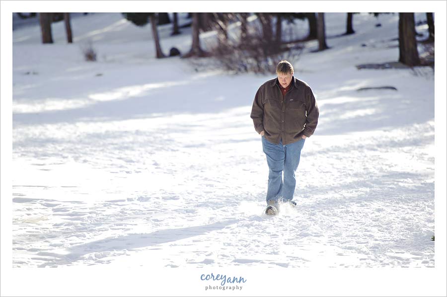 man walking across frozen echo lake near mount evans